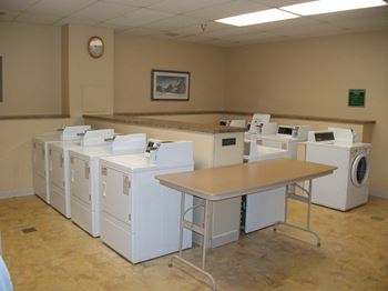 a group of washing machines in a room with a table